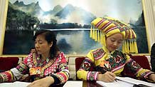 Huang Rumei (L) and Xiang Huiling, deputies of Zhuang ethnic group to the Third Session of the National People's Congress (NPC) from southwest China's Guangxi Zhuang Autonomous Region, take notes during a panel discussion on the work report of the Standing Committee of the NPC in Beijing, China, March 10, 2010.
