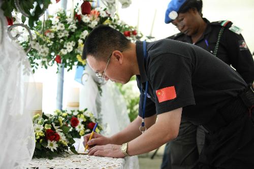 A member of Chinese peacekeeping anti-riot police team writes on condolence book in a ceremony commemorating the UN personnel that perished in Haiti&apos;s Jan. 12 earthquake in Port-au-Prince, capital of Haiti, March 9, 2010.