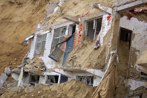 Houses are buried in a landslide occurred in Zizhou County of Yulin City, northwest China&apos;s Shaanxi Province, on March 10, 2010.