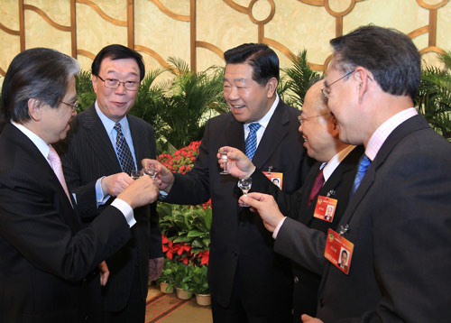 Jia Qinglin (3rd L), chairman of the National Committee of the Chinese People's Political Consultative Conference (CPPCC), toasts with deputies to the Third Session of the 11th CPPCC Conference from south China's Hong Kong Special Administrative Region (SAR) and Macao SAR during a reception in Beijing, capital of China, March 11, 2010. 