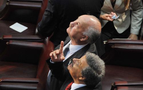 A man points to the ceiling at the Congress house in Valparaiso, Chile, on March 11, 2010.