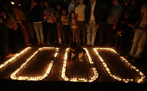 Palestinians light candles forming the number 1000 during a rally marking 1000 days of the Israeli blockade on the Gaza Strip, in Gaza City on March 11, 2010.