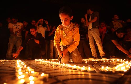 Palestinians light candles forming the number 1000 during a rally marking 1000 days of the Israeli blockade on the Gaza Strip, in Gaza City on March 11, 2010.