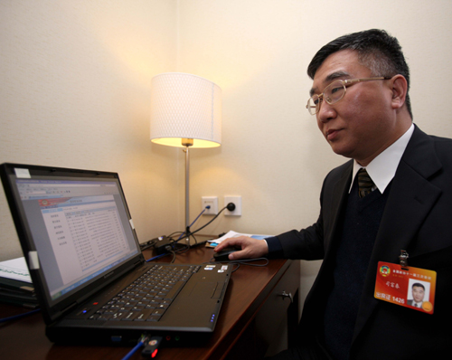 Si Fuchun, member to the Third Session of the 11th National Committee of the Chinese People's Political Consultative Conference (CPPCC), go through proposals on the official website of the 11th CPPCC in Beijing, China, March 10, 2010.