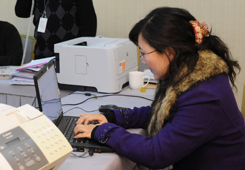 Cui Xin, staff member of the media liaison office which serves for the Third Session of the 11th National Committee of the Chinese People's Political Consultative Conference (CPPCC), send group short messages of interview notices to journalists in Beijing, China, March 10, 2010. 