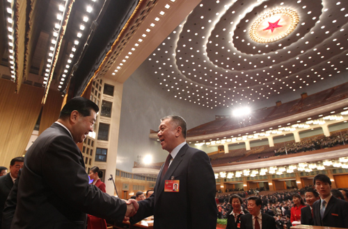 Jia Qinglin (L), chairman of the National Committee of the Chinese People's Political Consultative Conference (CPPCC), congratulates Edmund Ho Hau Wah, newly-elected vice chairman of the 11th CPPCC National Committee, after the closing ceremony of the Third Session of the 11th CPPCC National Committee at the Great Hall of the People in Beijing, capital of China, March 13, 2010.