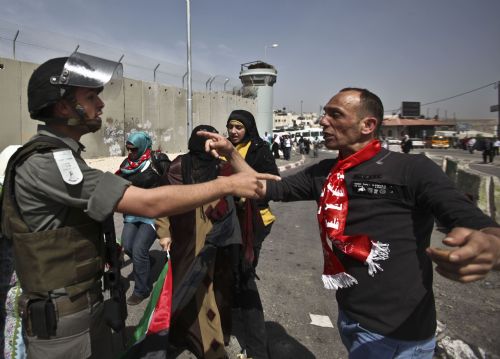 An Israeli soldier (L) argues with a Palestinian demonstrator during a demonstration against Israeli closure in Qalandiya checkpoint near Jerusalem City on March 13, 2010. 