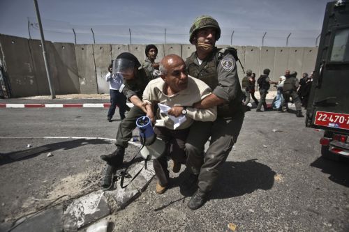 Israeli soldiers arrest a Palestinian man during a demonstration against Israeli closure in Qalandiya checkpoint near Jerusalem City on March 13, 2010.