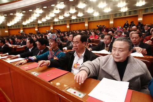 Deputies to the Third Session of the 11th National People's Congress (NPC) press the buttons to vote during the closing meeting the Third Session of the 11th NPC at the Great Hall of the People in Beijing, China, March 14, 2010. 