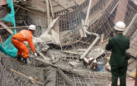 Chinese rescuers examine the debris of a collapsed passage that connects two halls of the Guiyang International Exhibition Center under construction in Guiyang, Southwest China's Guizhou Province, March 14, 2010. 