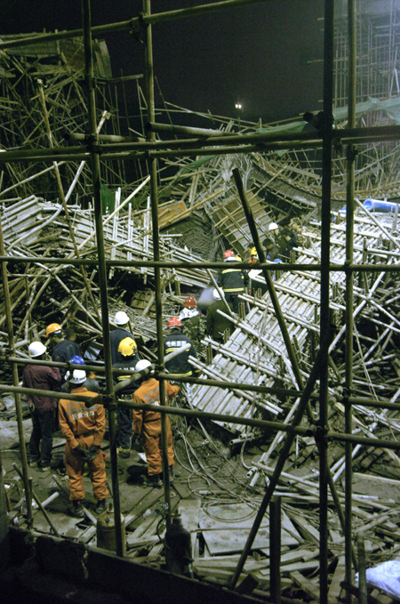 Chinese rescuers examine the debris of a collapsed passage that connects two halls of the Guiyang International Exhibition Center under construction in Guiyang, Southwest China's Guizhou Province, March 14, 2010. 