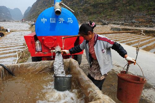 A local villager carries the water barrels to irrigate the field suffering the severe drought in Changshun County of southwest China's Guizhou Province, March 14, 2010.