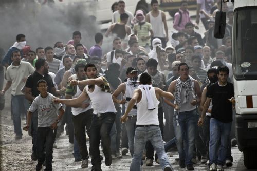 Palestinian protesters hurl stones towards Israeli troops during clashes at Atara Checkpoint in the north of the West Bank city of Ramallah, on March 15, 2010.