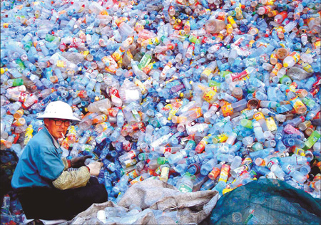 A man sorts empty plastics bottles into different categories at a garbage recycling plant in the suburbs of Huaibei, a city in Anhui Province. China consumes 52 million tons of plastics a year. 