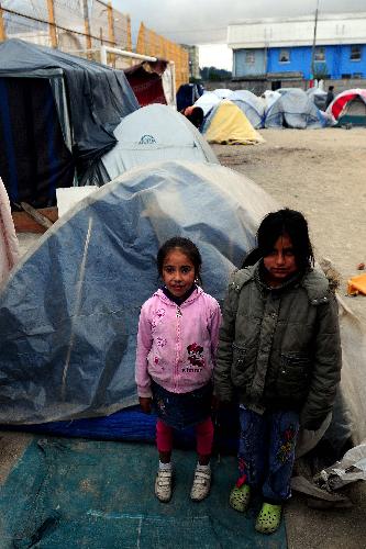 Two children stands in front of a tent in Conception, Chile, on March 17, 2010. A 8.8-magnitude earthquake battered the Chilean city on Feb. 27.
