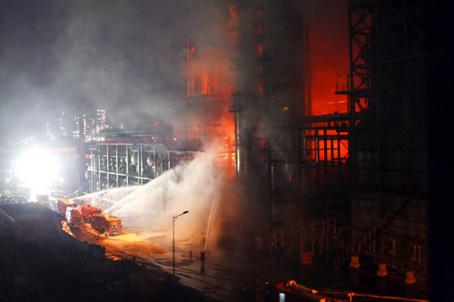 Firefighters try to put out the fire an oil refinery of Sinopec Guangzhou Co on March 18, 2010.