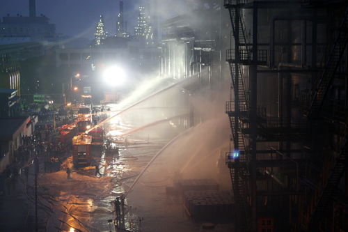 Firefighters try to put out the fire an oil refinery of Sinopec Guangzhou Co on March 18, 2010.