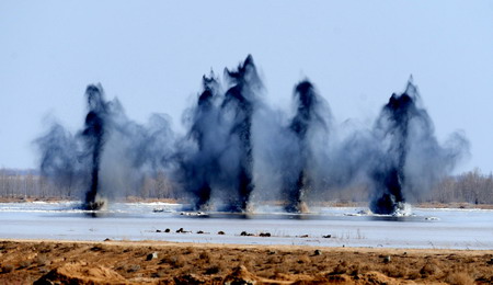 The explosions are seen as they break the ice of the dangerous Minjibu Reach of the Yellow River under the bombardment in Tumd Right Banner of north China&apos;s Inner Mongolia Autonomous Region on March 22, 2010. 