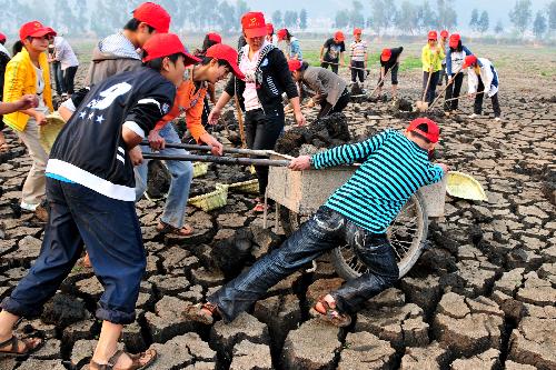Young volunteers clear sludge at the bottom of the Chirui Lake at Shiping County, southwest China's Yunnan Province, March 24, 2010. 