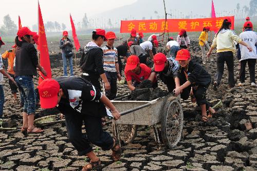 Young volunteers clear sludge at the bottom of the Chirui Lake at Shiping County, southwest China's Yunnan Province, March 24, 2010. 