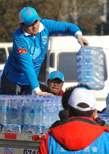 Vounlunteers load the donations at a donation site in Fengtai Sports Center in Beijing, China, March 28. 2010. 