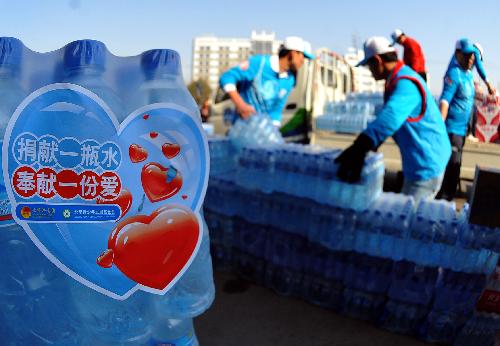 Vounlunteers load the donations at a donation site in Fengtai Sports Center in Beijing, China, March 28. 2010. Nearly 470,000 bottles of water, which have been collected during a public donation campaign held in Beijing recently, now is head for the drought-hit southwestern provinces in China on Sunday.