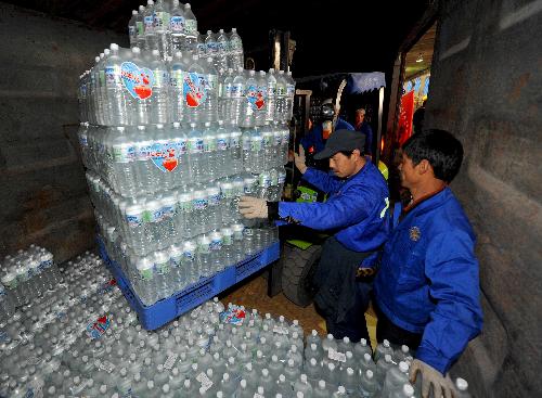 Vounlunteers load the donations at a donation site in Fengtai Sports Center in Beijing, China, March 28. 2010. Nearly 470,000 bottles of water, which have been collected during a public donation campaign held in Beijing recently, now is head for the drought-hit southwestern provinces in China on Sunday.