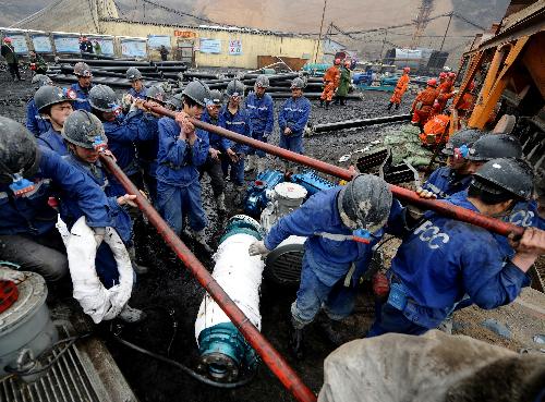 Rescuers carry pumps at the site of a flooding accident of Wangjialing Coal Mine, sitting astride Xiangning County of Linfen City and Hejin City of Yuncheng City, in north China's Shanxi Province, on March 29, 2010.
