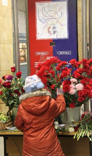 A child places flowers in memory of the bomb victims at the Cultural Park subway station in Moscow, capital of Russia, March 29, 2010. 