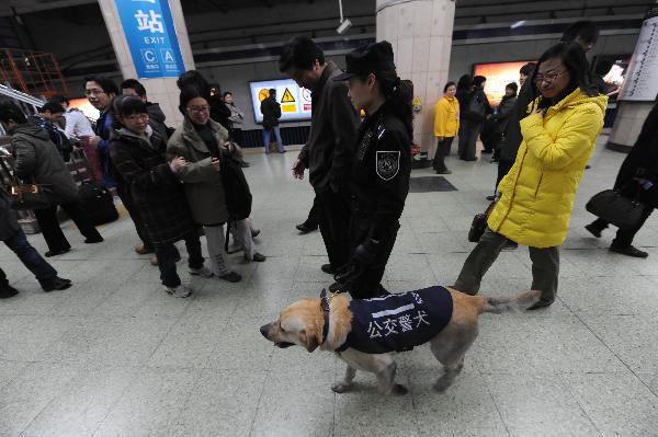 A policewoman patrols a subway station with police dog in Beijing, capital of China, on March 30, 2010.