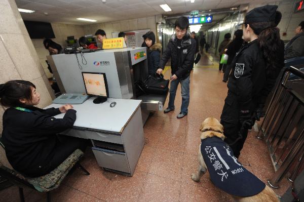 Passengers go through security check at a subway station in Beijing, capital of China, on March 30, 2010.