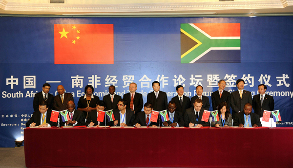Jia Qinglin (C Back), chairman of the National Committee of the Chinese People's Political Consultative Conference, attends the signing ceremony of a package of deals on Chinese enterprises' purchasing products worth more than US$300 million from South Africa, in Pretoria, South Africa, March 31, 2010.