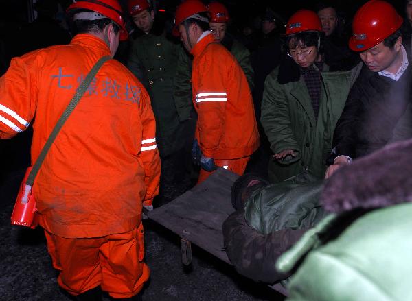 A rescued miner is carried out of a shaft at Longpeng Coal Mine in Qitaihe City, northeast China's Heilongjiang Province, on April 6, 2010. 