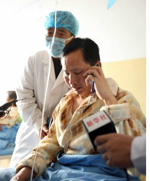 Wang Renfang, a survivor of flooded Wangjialing Coal Mine, cries when he has a phone call with his wife at a hospital in Hejin City of north China's Shanxi Province, on April 8, 2010. 