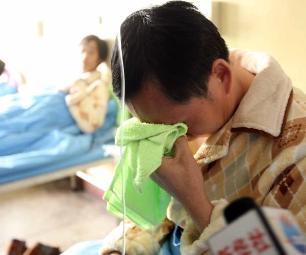 Wang Renfang, a survivor of flooded Wangjialing Coal Mine, cries when he has a phone call with his wife at a hospital in Hejin City of north China's Shanxi Province, on April 8, 2010. 