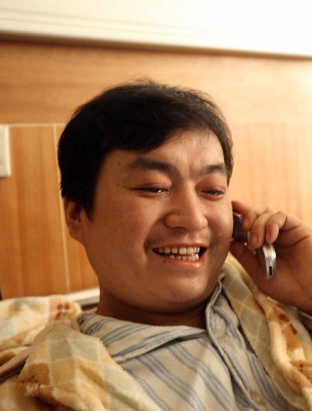 Liu Xuejun, a survivor of flooded Wangjialing Coal Mine, has a phone call with his wife and son at a hospital in Hejin City of north China's Shanxi Province, on April 8, 2010. 