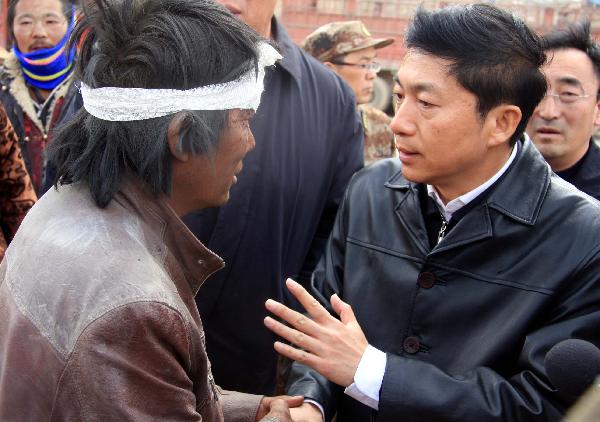 Luo Huining (R), governor of northwest China's Qinghai Province, talks to an injured resident after a quake in Yushu County, northwest China's Qinghai Province, April 14, 2010.