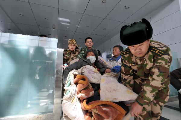 Rescuers from Shenzhen (south China's Guangdong Province) transport injured people to get on the plane at Yushu Airport in the 7.1-magnitude-earthquake-hit Yushu County, northwest China's Qinghai Province, April 15, 2010.