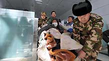 Rescuers from Shenzhen (south China's Guangdong Province) transport injured people to get on the plane at Yushu Airport in the 7.1-magnitude-earthquake-hit Yushu County, northwest China's Qinghai Province, April 15, 2010.