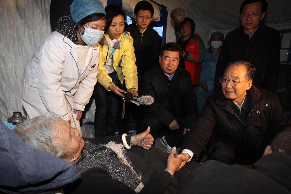 Chinese Premier Wen Jiabao (R) visits a Tibetan woman in Yushu, northwest China's Qinghai Province, April 15, 2010. 
