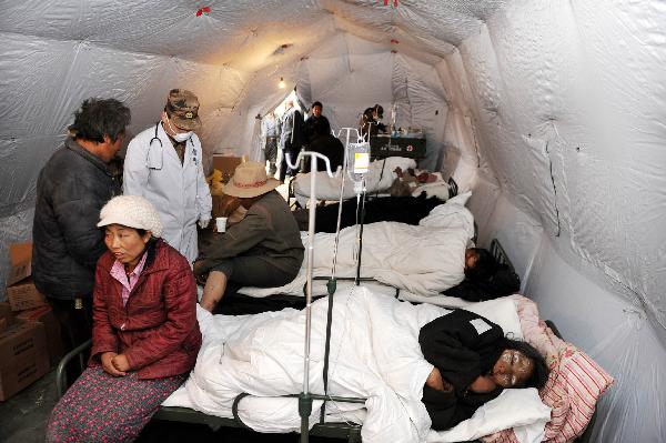 Injured people receive treatment at a military tent hospital in Gyegu Town of earthquake hit Yushu County of northwest China's Qinghai Province, April 16, 2010. Dozens of medical team have rushed to Yushu from all over China since the 7.1-magnitude quake struck here early Wednesday.