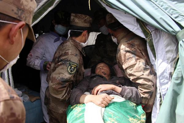 Military doctors move an injured into a military tent hospital in Gyegu Town of earthquake hit Yushu County of northwest China's Qinghai Province, April 16, 2010. Dozens of medical team have rushed to Yushu from all over China since the 7.1-magnitude quake struck here early Wednesday.