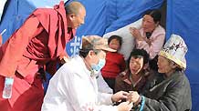A military doctor cures an elder at a military tent hospital in Gyegu Town of earthquake hit Yushu County of northwest China's Qinghai Province, April 16, 2010. Dozens of medical team have rushed to Yushu from all over China since the 7.1-magnitude quake struck here early Wednesday.