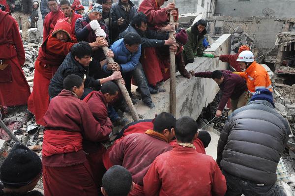 Local people and monks help rescuer searching for survivors among debris of a house at Gyegu Town of earthquake hit Yushu County of northwest China&apos;s Qinghai Province, April 16, 2010. The rescuers have been doing unremitting efforts to save people&apos;s lives during the &apos;golden 72 hours&apos; since the 7.1-magnitude quake struck Yushu early Wednesday.