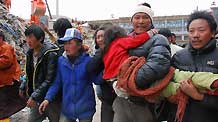 People carry a girl who is rescued from debris of Minzu Hotel to receive medical treatment at Gyegu Town of earthquake hit Yushu County of northwest China's Qinghai Province, April 16, 2010.