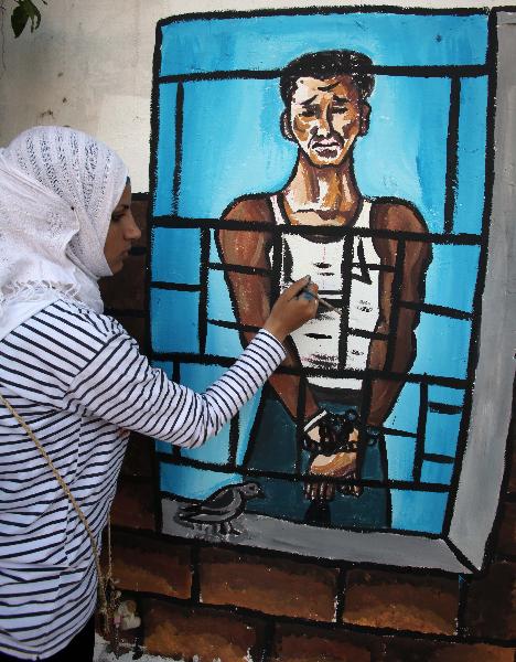 A Palestinian draws a graffiti to mark the Palestinian prisoner day in Gaza city on April 16, 2010.