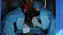Medical workers treat an injured woman in quake-hit Yushu County, northwest China's Qinghai Province, April 16, 2010.