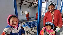 Three locals stand outside a prefab house being set up in quake-hit Yushu County, northwest China's Qinghai Province, April 17, 2010. Setting of prefab houses is underway for locals who became homeless after the 7.1-magnitude earthquake hit Yushu of Qinghai Province on Wednesday.