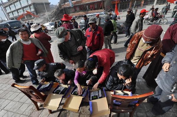 Local residents make free phone calls at a service site in quake-hit Yushu County, northwest China's Qinghai Province, April 17, 2010. China's major telecommunication operators are providing free phone call service to local quake victims in Yushu County.