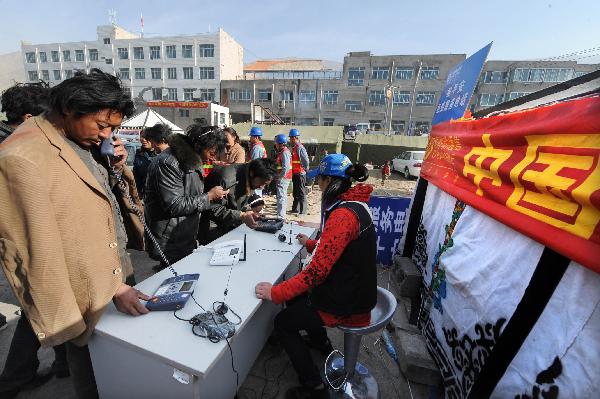 Local residents make free phone calls at a service site in quake-hit Yushu County, northwest China's Qinghai Province, April 17, 2010. China's major telecommunication operators are providing free phone call service to local quake victims in Yushu County.